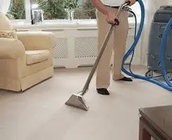 Carpet cleaning professional removing dirt and stains with a hot-water extraction tool in a home, Kansas City, MO.