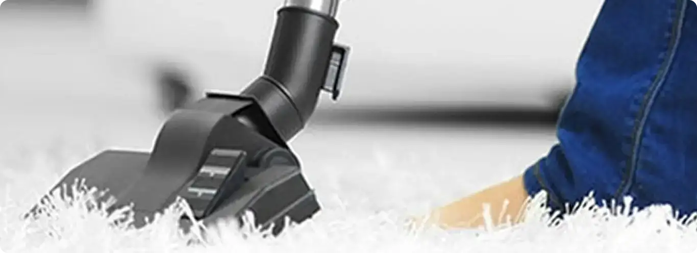 Close-up of a professional vacuuming a white carpet in Shawnee.